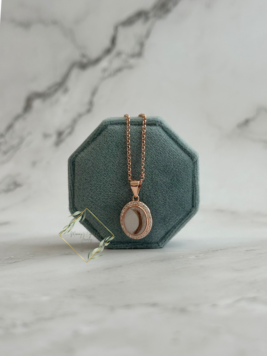 Oval bezel necklace with faux diamond stones encompassing it.