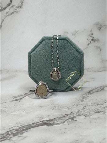 Large keepsake teardrop ring encompassed with faux diamonds paired with a keepsake teardrop necklace surrounded with faux diamonds. 